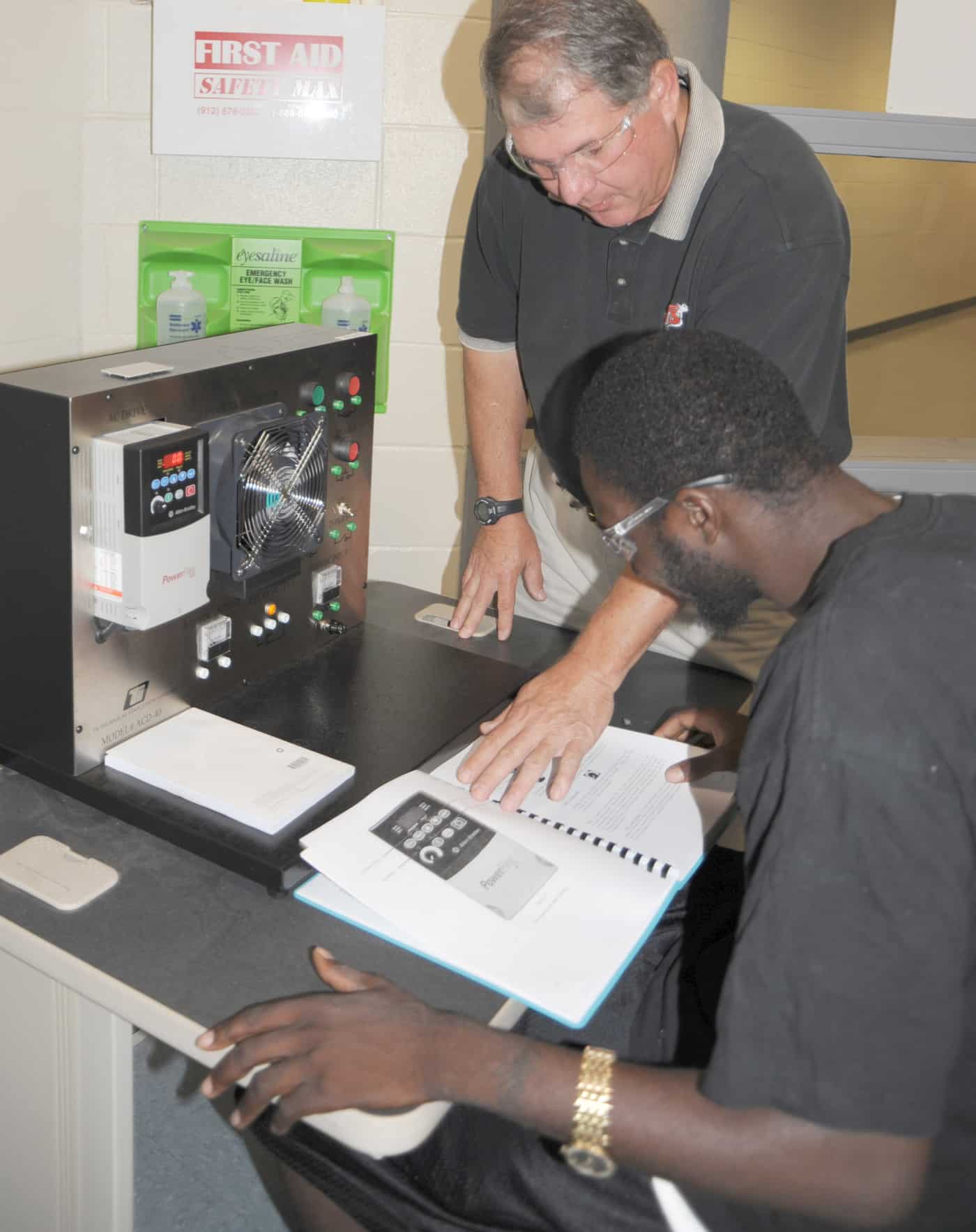 Electronics instructor Mike Enfinger teaches a student from the book.