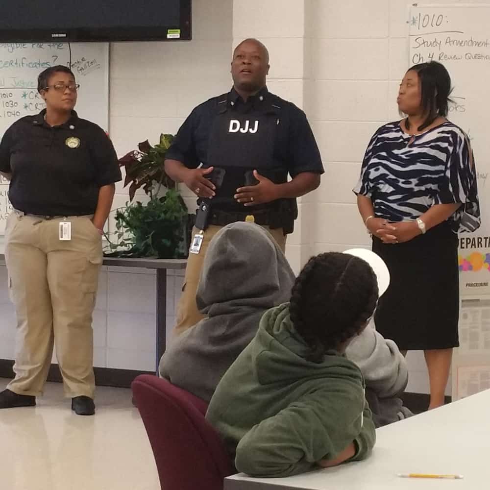 Three representatives from the Department of Juvenile Justice (DJJ) speak to a class.