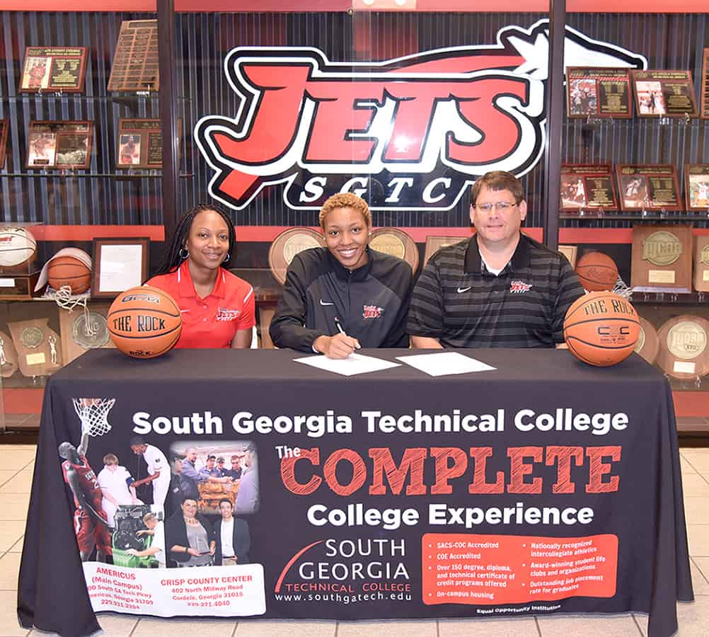 Desiree Corbin (center) is pictured with SGTC Lady Jets Assistant Coach Kezia Conyers and Head Coach/Athletic Director James Frey as she signs a letter of intent to play basketball for East Carolina University.
