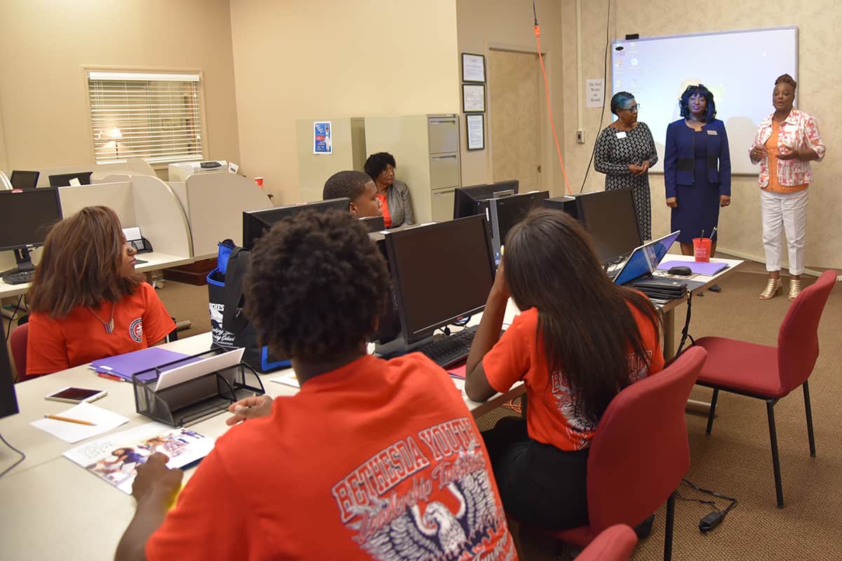 SGTC’s Cynthia Carter, Deo Cochran, and Vickie Austin are pictured from left to right as they speak to group of people
