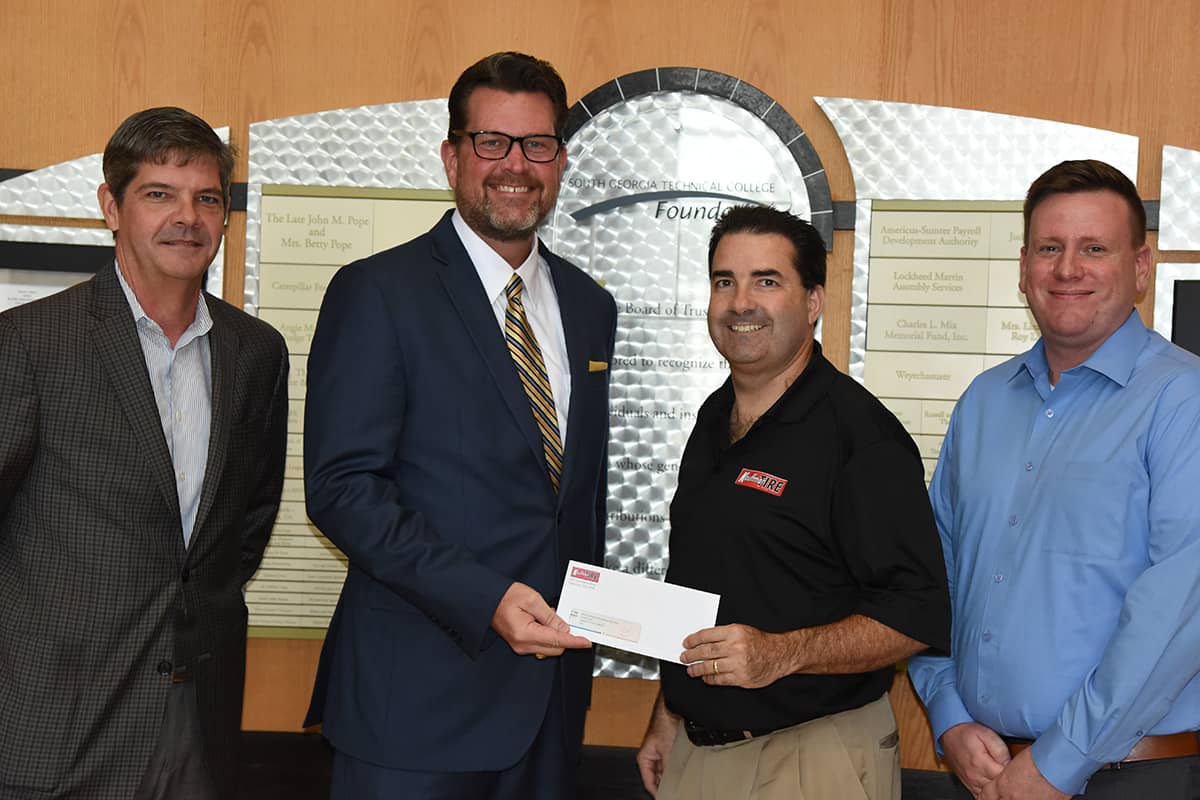 Theron Garcia, Vice President of Human Resources for Kauffman Tire is presenting a scholarship check to South Georgia Technical College President Dr. John Watford