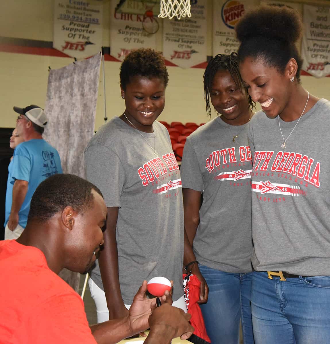 Lady Jets getting a signed football from Leonard Pope