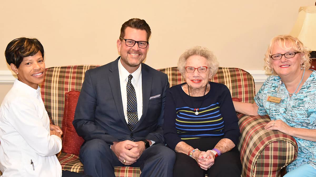 South Georgia Technical College President Dr. John Watford (seated center left) is shown above thanking Marie Waitsman (seated center right) for the new endowed healthcare scholarship that she and her family endowed in honor of two longtime Magnolia Manor employees, “Kitty” LaDaisy Battle (kneeling left) and Laurie Jessop. (kneeling right).