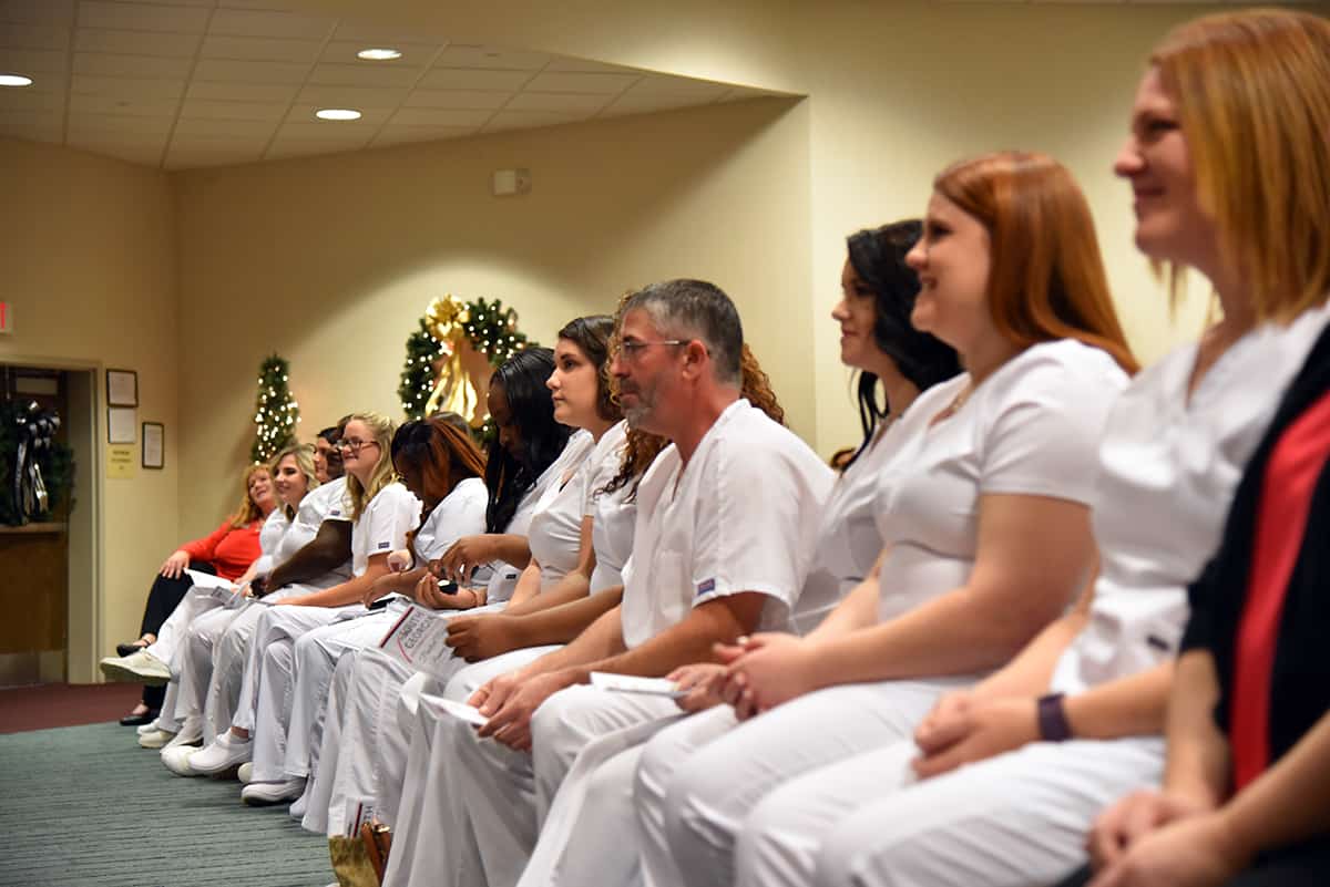Practical Nursing program graduates sit on the front row waiting to be pinned at a recent graduation and Pinning Ceremony for the program.