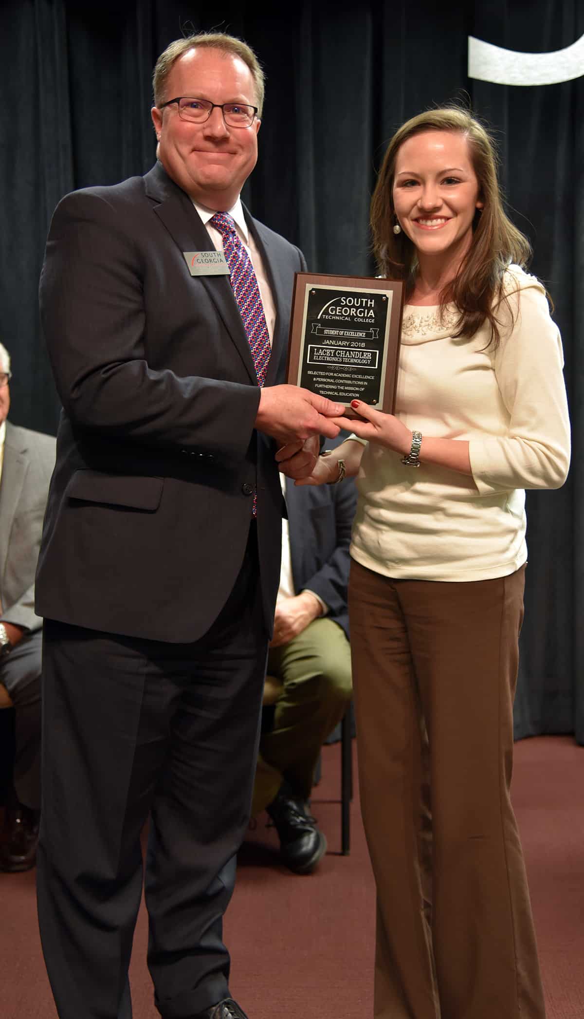 Lacey Chandler, Electronics Technology, accepts her Student of Excellence plaque from Vice President of Academic Affairs David Kuipers.