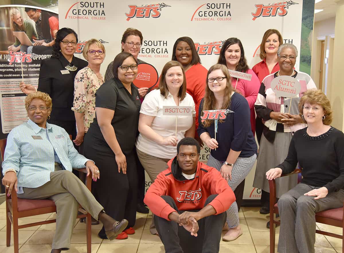 Shown above are some of the SGTC staff members that work in the Admissions, Registrar, Administrative Services, and Foundation and Marketing offices in the Odom Center on the Americus campus. Each of these individuals are alumni of South Georgia Technical College who chose to give back to students after graduation by working at the college. Many have gone on to earn other degrees, but they are still proud of their alma mater. They are also shown with one of the SGTC Jets basketball players who is also a work-study student, Malik Wilson, (seated center) and they are planning to come out and support him and his teammates at the SGTC Alumni/Sophomore Celebration event on Saturday, February 10th.