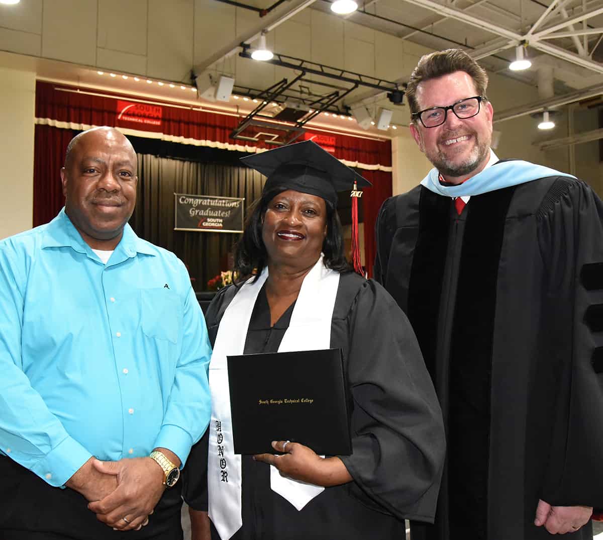 South Georgia Technical College President Dr. John Watford (right) is shown above congratulating Eva Porter for graduating with her Early Childhood Care and Education diploma at South Georgia Technical College. Mrs. Porter started her classes in Marion County and then completed the diploma by taking classes on the Americus campus and on-line. Dr. George Porter is also shown congratulating his wife and thanking Dr. Watford for this great partnership with the Marion County Schools.