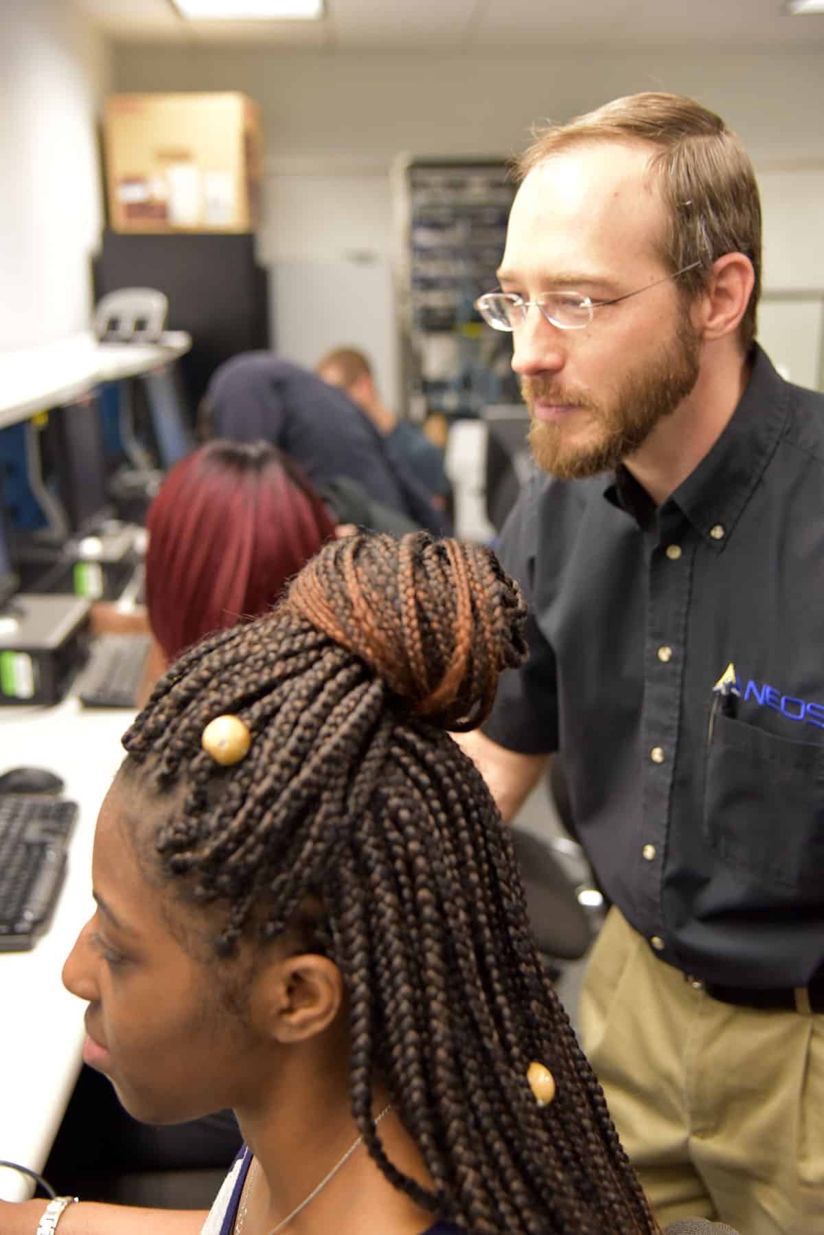 Workshop facilitator and SGTC alumnus Christopher Saunders looks onto the computer screen over a student’s shoulder as they get one-on-one training during the recent workshop for current Computer Information System students.