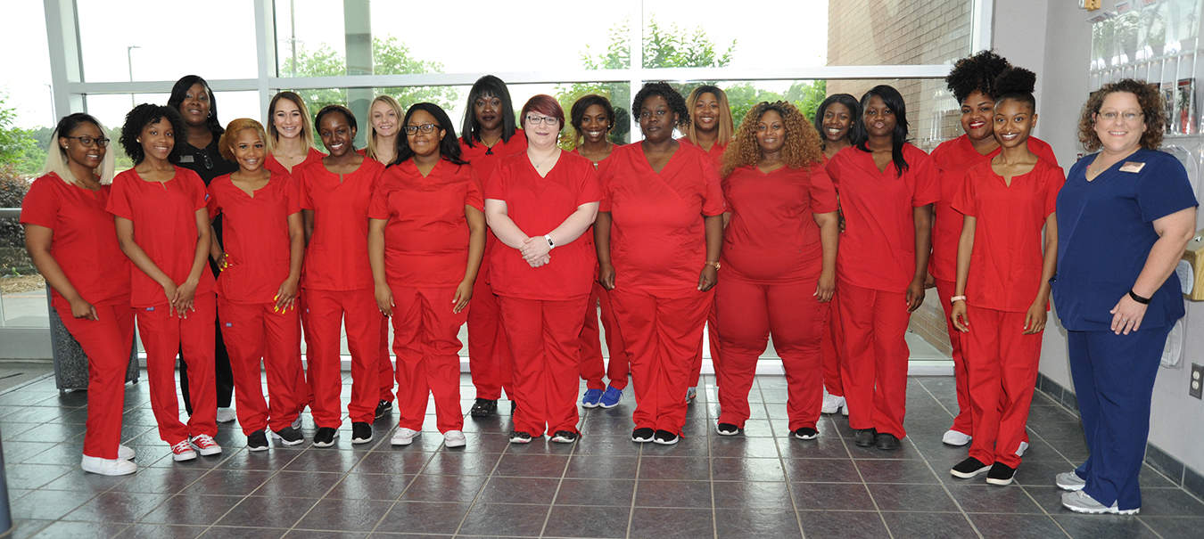 South Georgia Technical College’s newest Certified Nurse Aide program graduates stand in their red scrubs with instructors Shanice Barnum (Black scrubs, back) and Brandy Nipper (Blue scrubs, front) before their recent pinning ceremony.