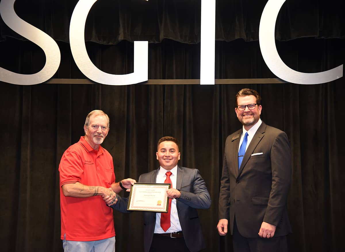 Lou Crouch of Byron is shown above presenting Santiago Rueda of Americus with the Lou Crouch Law Enforcement Scholarship during the South Georgia Technical College Law Enforcement Academy 18-01 graduation ceremony recently. SGTC President Dr. John Watford is also shown.