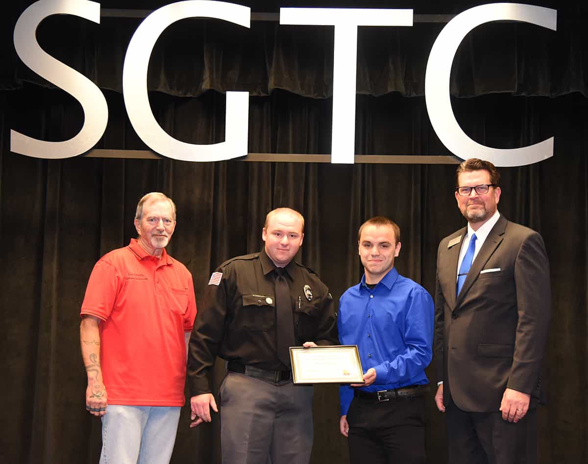 Lou Crouch is shown above with William Shelby Cloniger who is being presented with the Smallwood-Sondron Law Enforcement Academy Scholarship by Ethan Sondron, son of fallen officer Patrick Sondron, and South Georgia Technical College President Dr. John Watford.