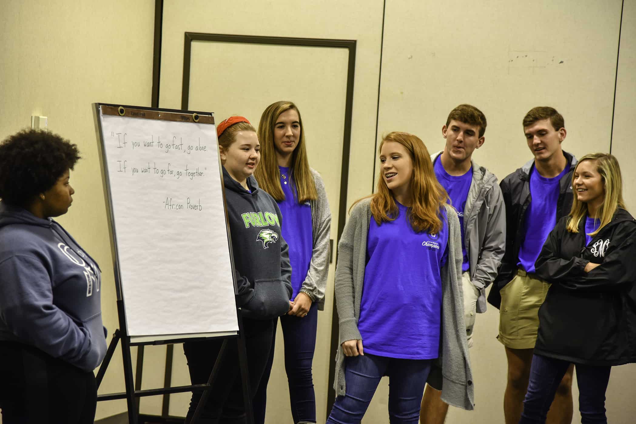 a girl reads a quote large easle