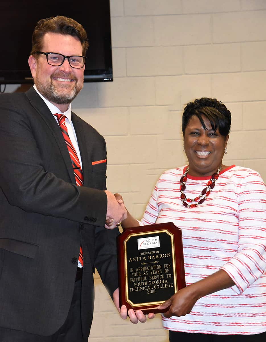 South Georgia Technical College President Dr. John Watford is shown above presenting Annita Carter Barron with a plaque for over 25 years of service to the students at South Georgia Technical College.
