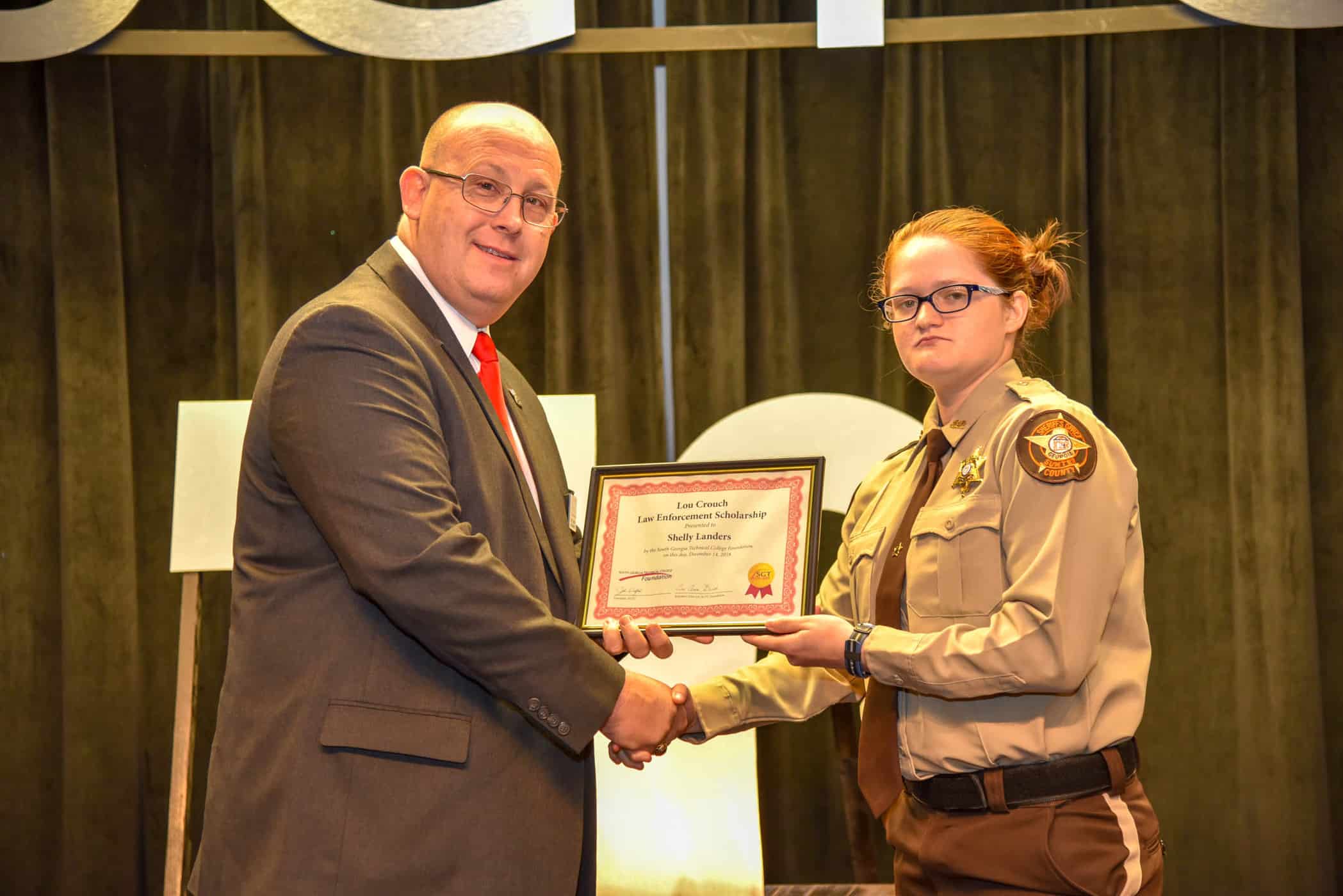 South Georgia Technical College Law Enforcement Academy Director Brett Murray is shown above presenting the Lou Crouch Scholarship to Shelly Landers of Americus at the SGTC Law Enforcement Academy graduation 18-02 recently. Lou Crouch was unable to attend.