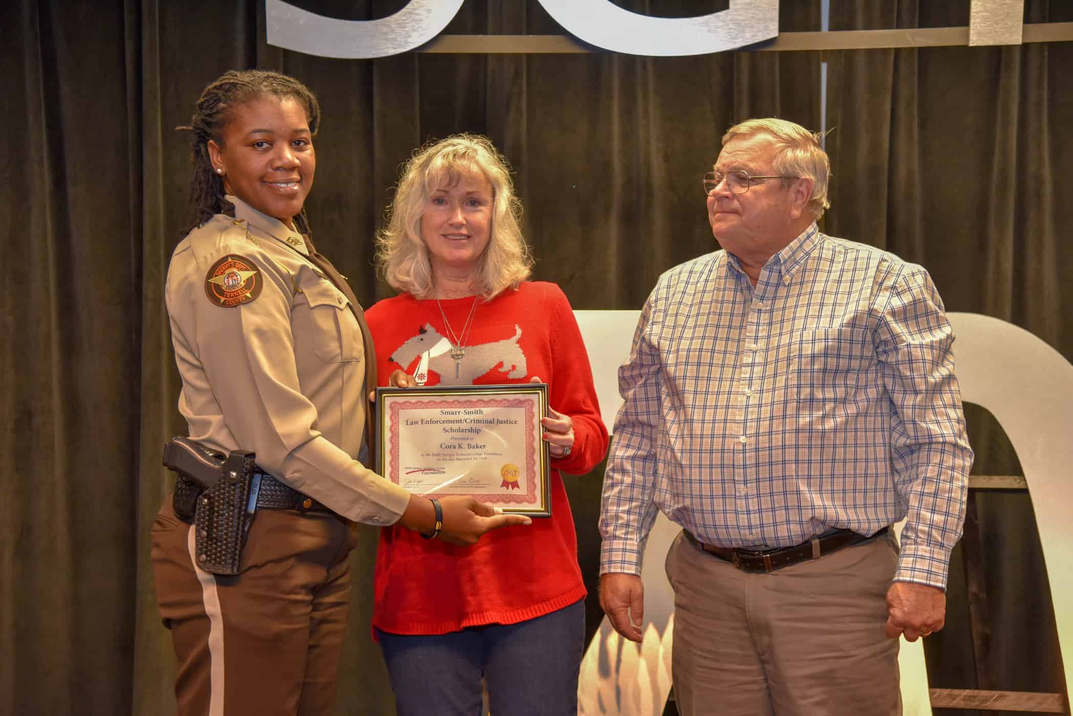 Paul and Sharon Smith Johnson (right to left) are shown above recognizing Cora Baker of the Terrell County Sheriff’s Office with a Smarr-Smith Criminal Justice Scholarship.