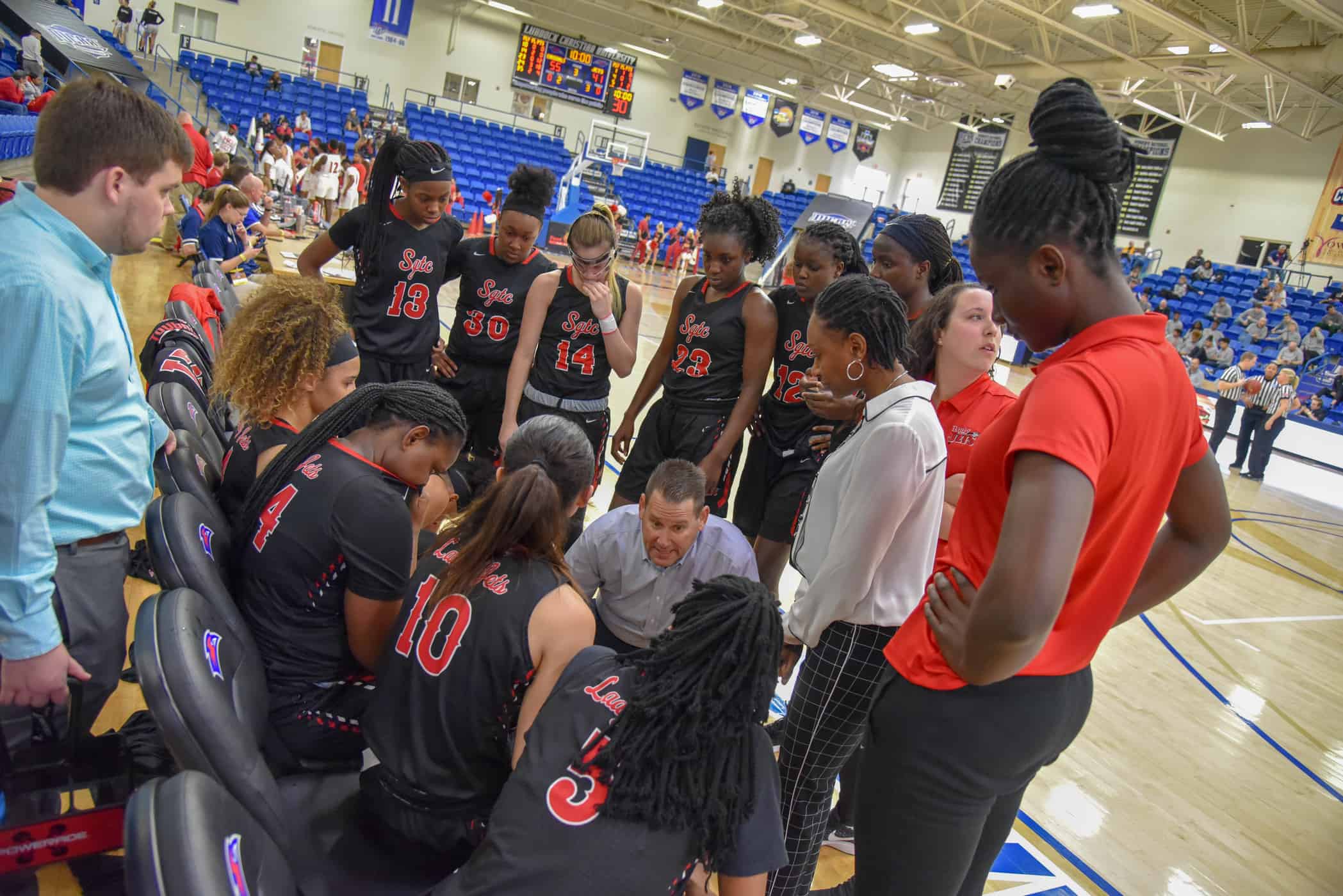 Lady Jets head coach James Frey talks strategy with the team during a timeout.