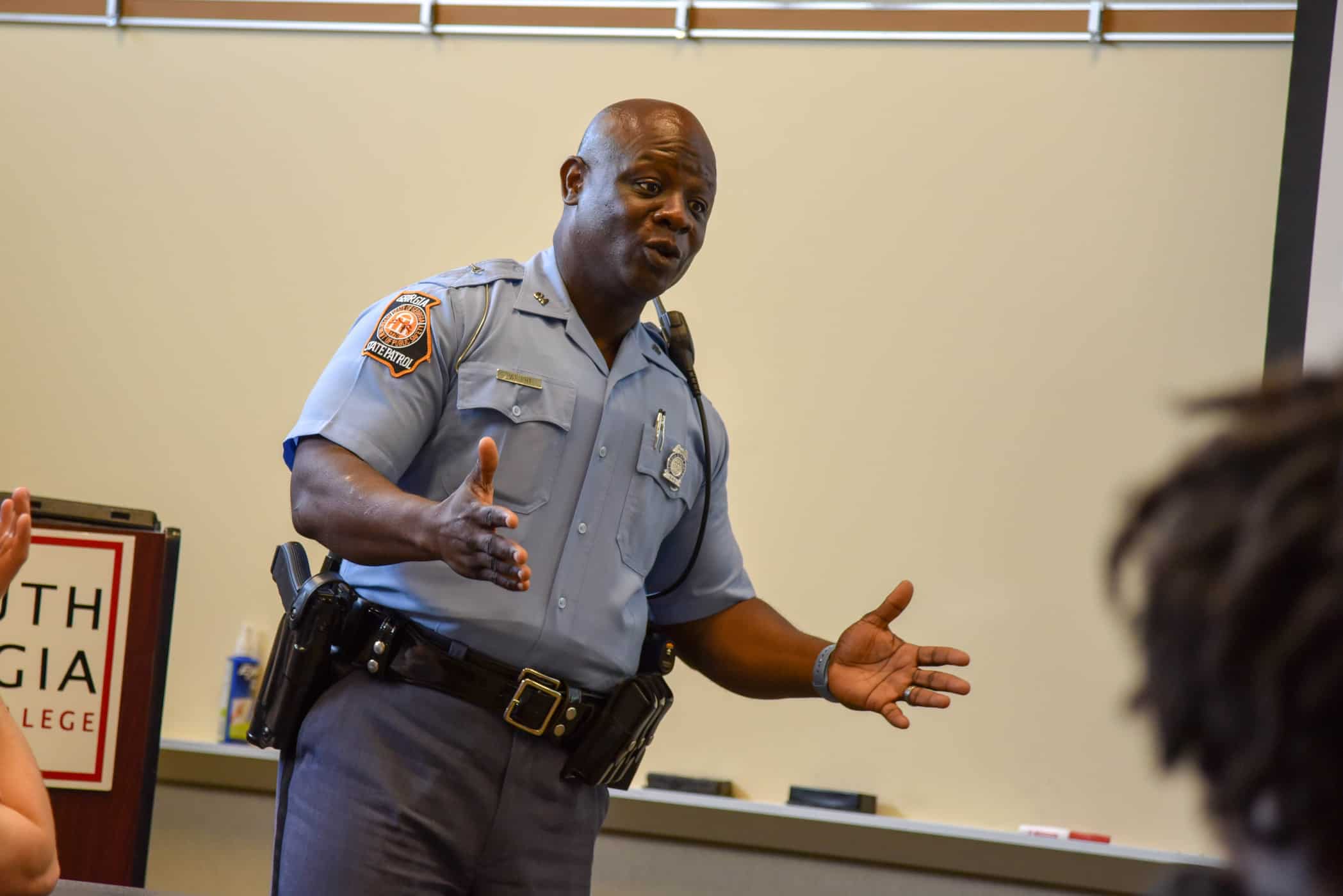A Georgia State Patrol trooper talks in front of a classroom