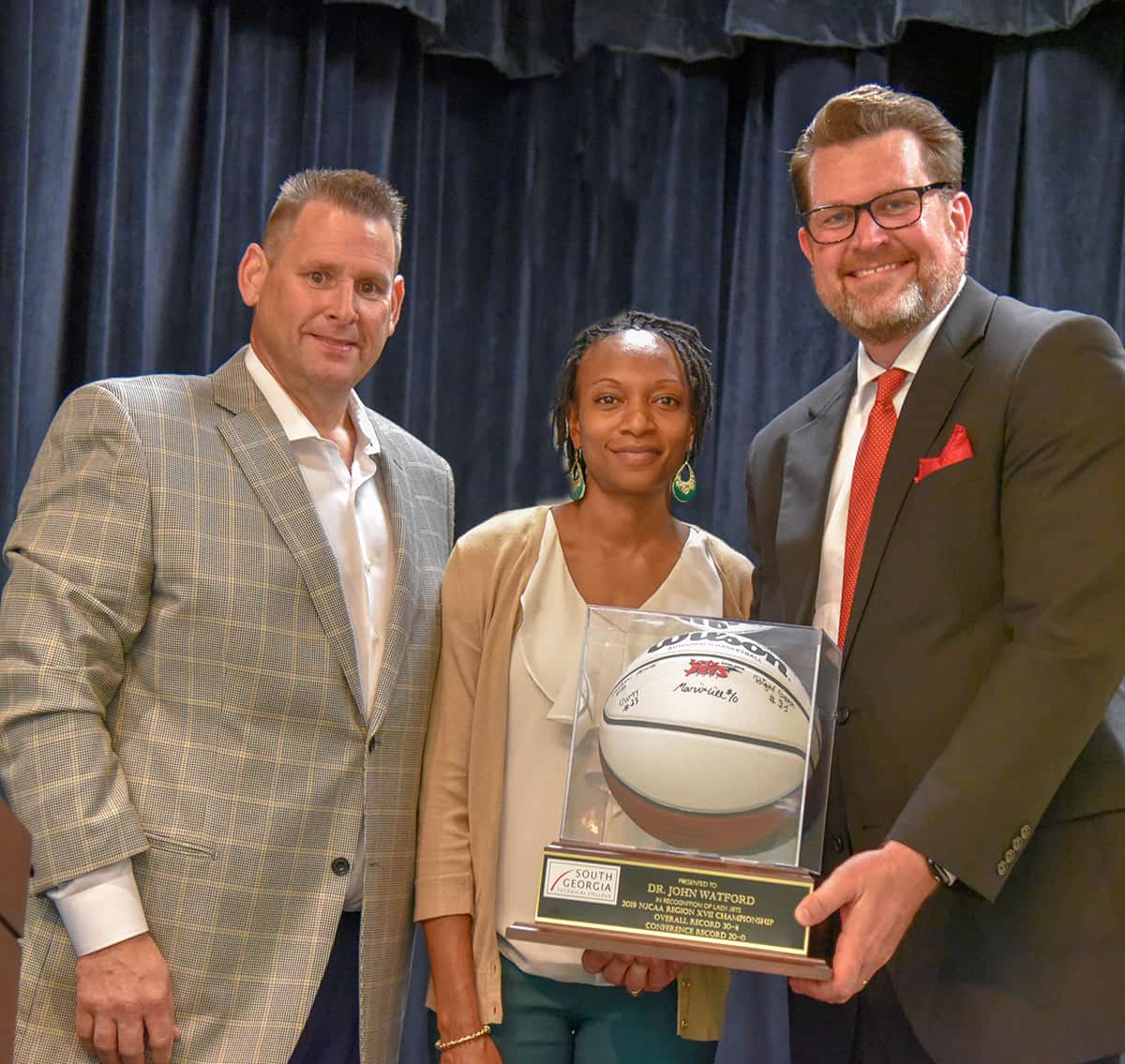 South Georgia Technical College President Dr. John Watford was presented with a framed autographed basketball by the Lady Jets for their trip to the national tournament in 2019. Shown above with Dr. Watford are Lady Jets head coach James Frey and Assistant Coach Kezia Conyers.