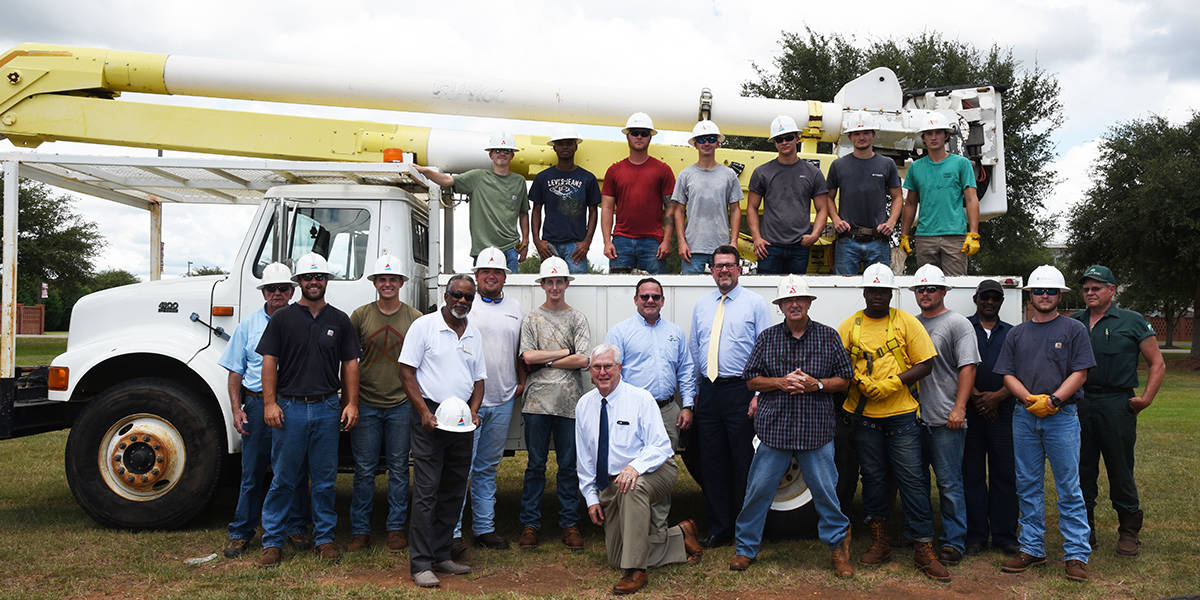 South Georgia Technical College President Dr. John Watford (c) is shown above with SGTC Vice President of Economic Development Wally Summers (kneeling) and Sumter EMC Vice President of Engineering David Brokamp and members of the current South Georgia Technical College Electrical Lineworker program and their instructors.