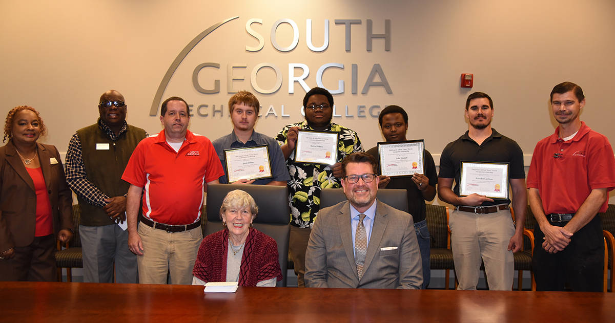South Georgia Technical College President Dr. John Watford (seated right) is shown above with Mrs. Ruth Jones (seated left) and other members of the Jones – Harris family and the student scholarship recipients and their instructor. Standing (l to r) on the back row are: SGTC’s Vickie Austin, Al Harris, and Tom Jones along with the Phil Jones – Al Harris Scholarship recipients, Jacob Hobbs of Ashburn, GA; Rashad Walden of Leary, GA; John McArthur Manuel of Montezuma, GA: and Brandon Laethem of Vienna. SGTC Automotive Technology Instructor Brandon Dean is also shown.
