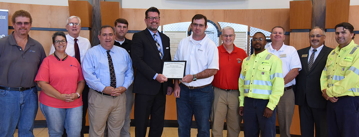 South Georgia Technical College President Dr. John Watford (left center) is shown above presenting the Certificate of Completion of Apprenticeship to Michael Timothy Jaskulski. Also shown (l to r) are: Imerys Operations Manager Jerry Lott, Rachel Jaskulski (Michael’s wife), SGTC Vice President of Economic Development Wally Summers, SGTC Director of Business and Industry Services Paul Farr, SGTC Electrical Systems Technology Instructor Tyler Wells, SGTC President Dr. John Watford, Michael Jaskulski, SGTC Industrial Systems Instructor Phil Deese, Imerys Electrical Engineering Manager Gabe Hillard, SGTC Electronics Systems Technology Instructor Mike Collins, SGTC Academic Dean David Finley, and Imerys Electrical Planner/Instrumentation Supervisor Chet Ragsdale.