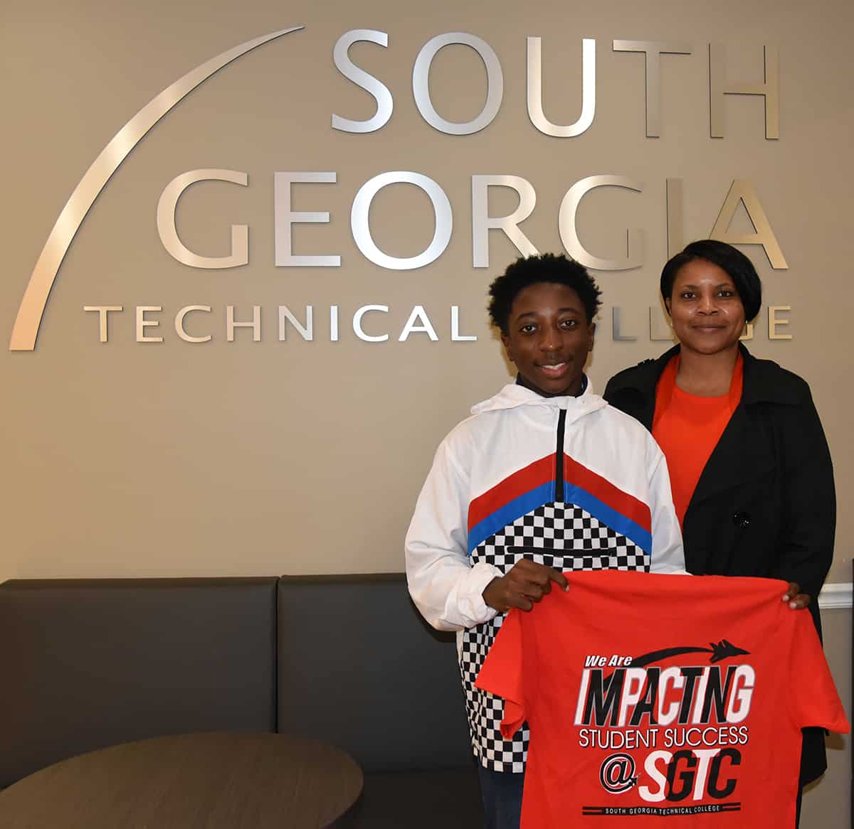 Chance Simpson is shown above with his Networking Computer Support instructor, Andrea Ingram with his t-shirt that shows that South Georgia Technical College is “Impacting His Success.”