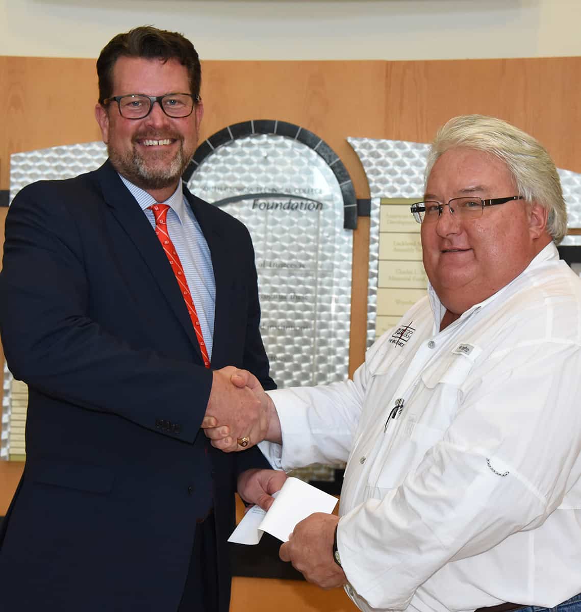 South Georgia Technical College President Dr. John Watford is shown above (l) accepting a donation for a new endowed Flex-Tec scholarship at South Georgia Technical College from Flex-Tec Plant Manager Rick Barnes.