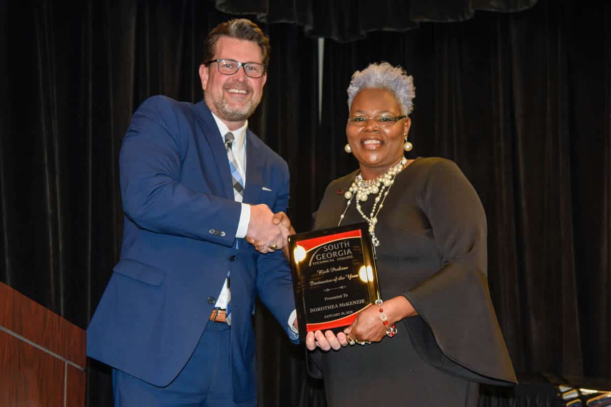 SGTC cosmetology instructor Dorothea Lusane McKenzie accepts the Rick Perkins Instructor of the Year Award from SGTC President Dr. John Watford.