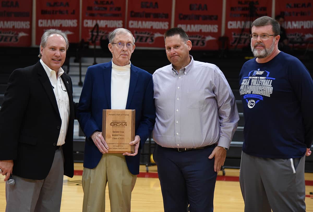 Georgia Collegiate Athletic Association Commissioner David Elder is shown above making the presentation to retired College of Coastal Georgia Athletic Director and men’s basketball coach Gerald Cox, Lady Jets head coach James Frey and Coach Cox’s son.