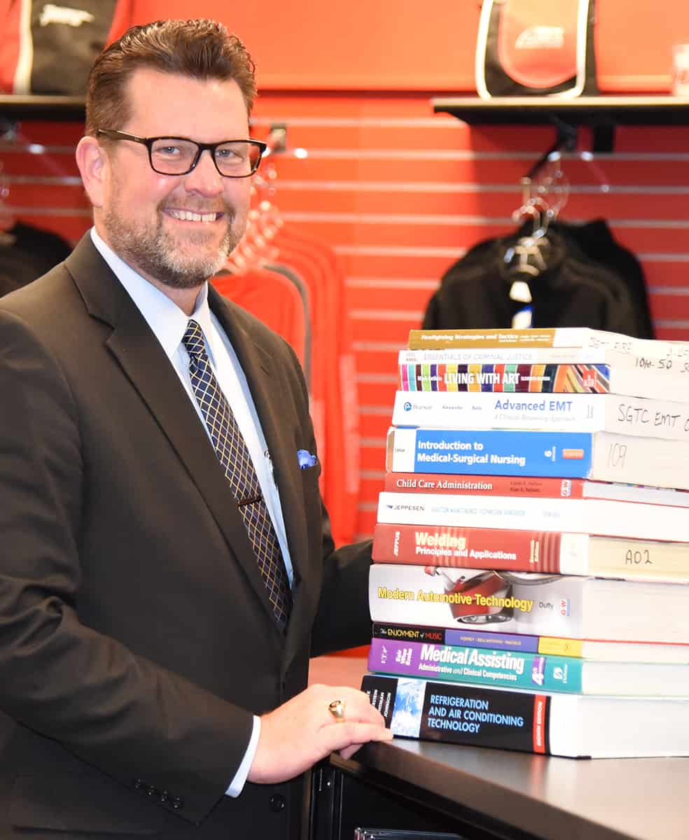 Shown above is South Georgia Technical College President Dr. Watford with a representative stack of college textbooks that are provided for students to use at no cost at SGTC when they enroll for summer semester. Classes start May 27th and only last eight weeks. It is a great time to look at expanding or exploring new career options.