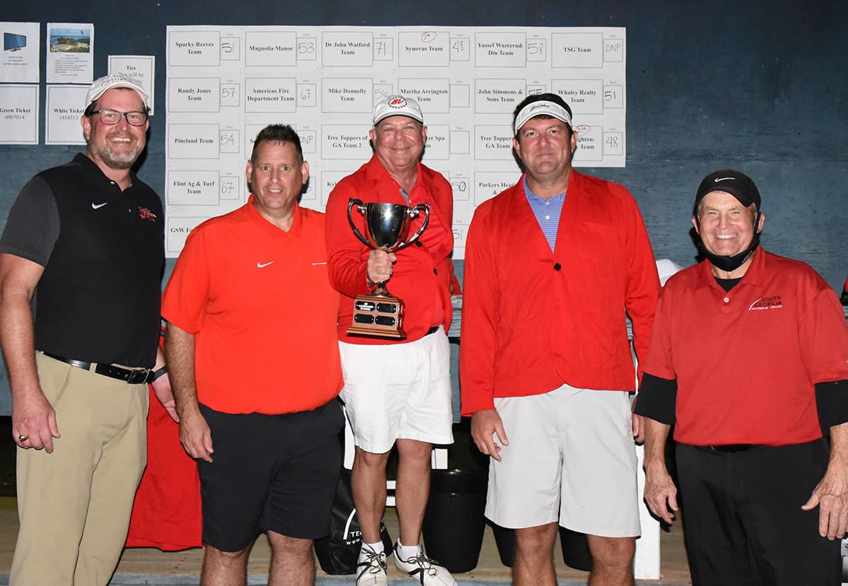 South Georgia Technical College President Dr. John Watford, and SGTC Athletic Director James Frey are shown above with the Synovus winning team of Buddy Guth and Jason Evans. Jodie Hayes was the third member of the winning team but he is not shown. SGTC President Emeritus Sparky Reeves is also shown congratulating the winning team.