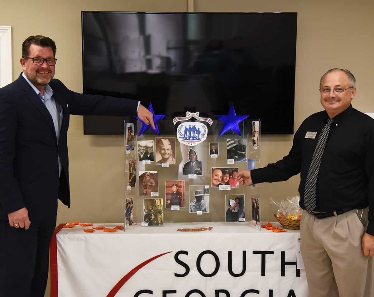 SGTC President John Watford (l) is shown above with SGTC Academic Dean Dr. David Finley in front of the display in the SGTC Odom Center. Dr. Watford is pointing to a photo of his father, who served in the military and Dr. Finley is pointing to his photo.
