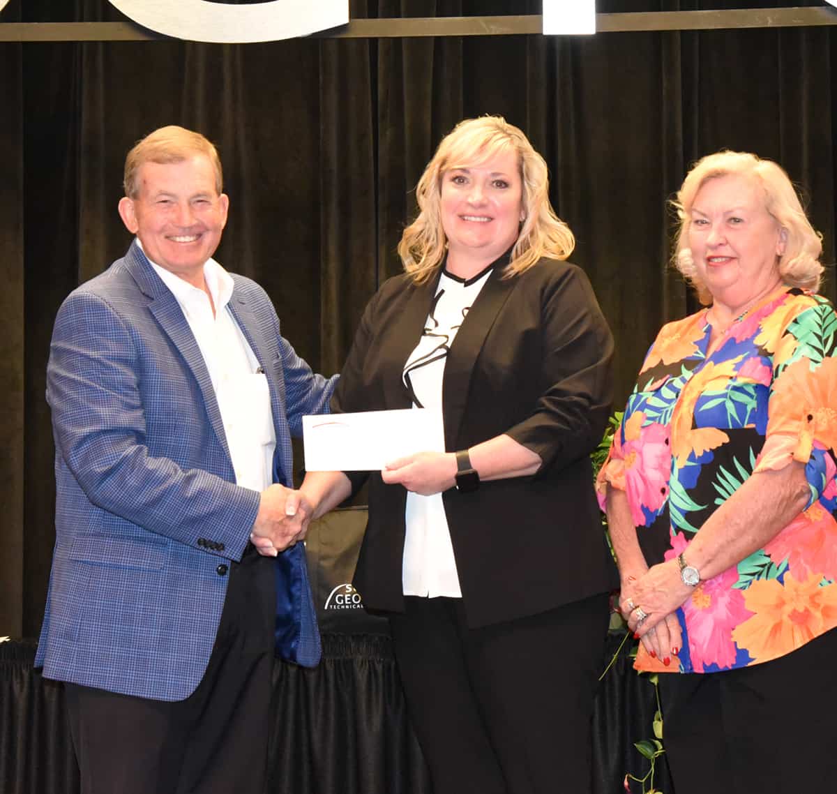 South Georgia Technical College President Emeritus Sparky Reeves (l) and Allene (right) are shown above presenting a scholarship check to 2021 GOAL winner Dawn Ammons.(c).