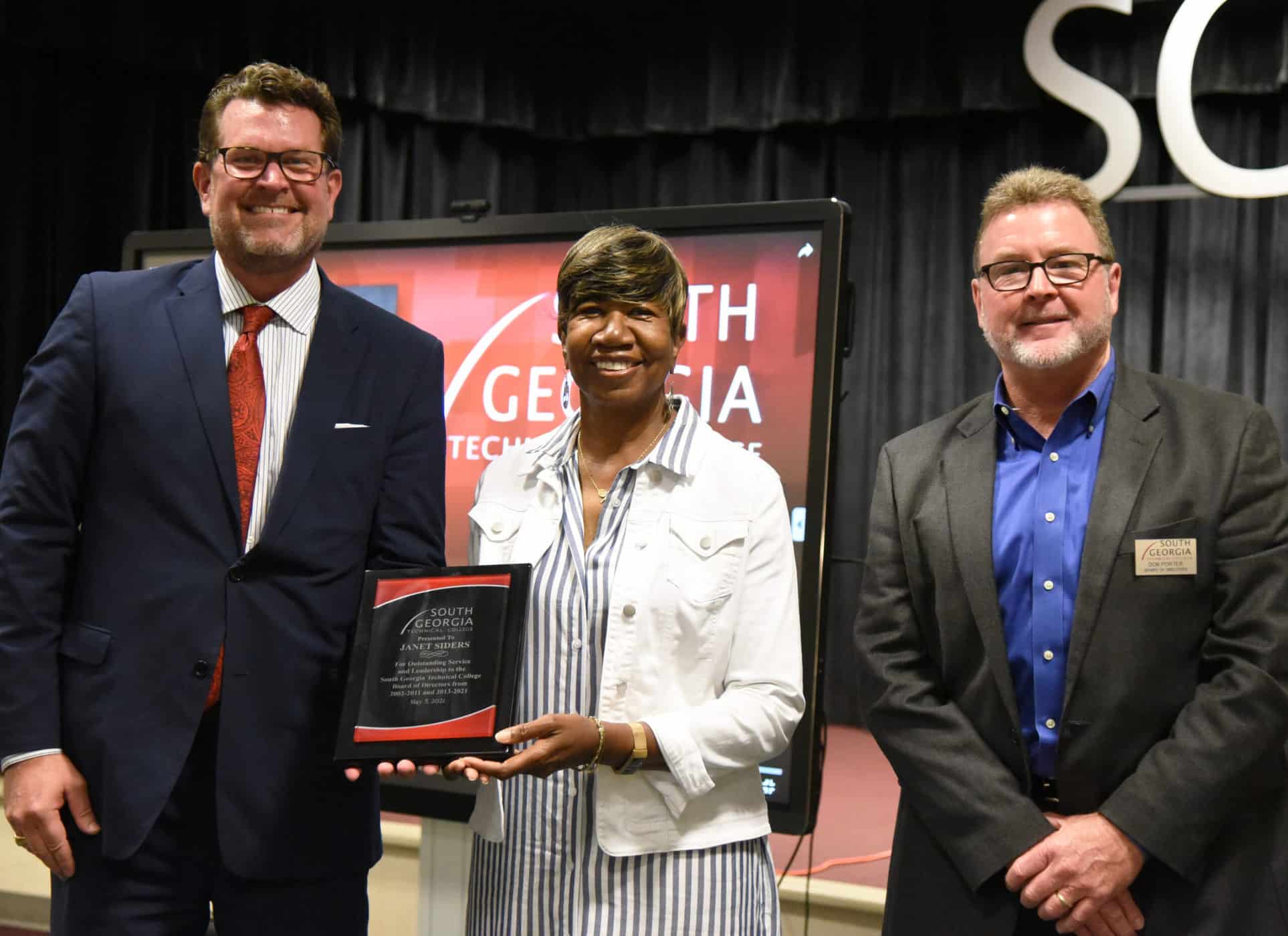 SGTC President Dr. John Watford (left) is shown above presenting outgoing SGTC Board of Directors Vice-Chair Janet Siders (center) with a plaque of appreciation for her service to the Board. SGTC Chairman Don Porter is also shown congratulating Siders.
