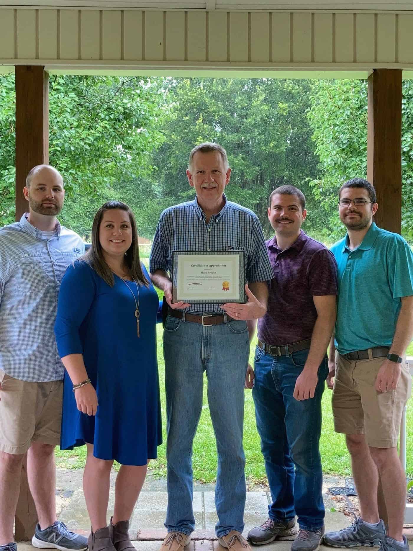 Mark Brooks (center) is shown above with his SGTC Foundation Scholarship certificate that was presented to him by his children after they established the Mark Brooks Scholarship for aviation maintenance students as a retirement gift. Shown (l to r) are Ben and Beth Brooks Wisham, Mark Brooks, Matthew Brooks and John Brooks.