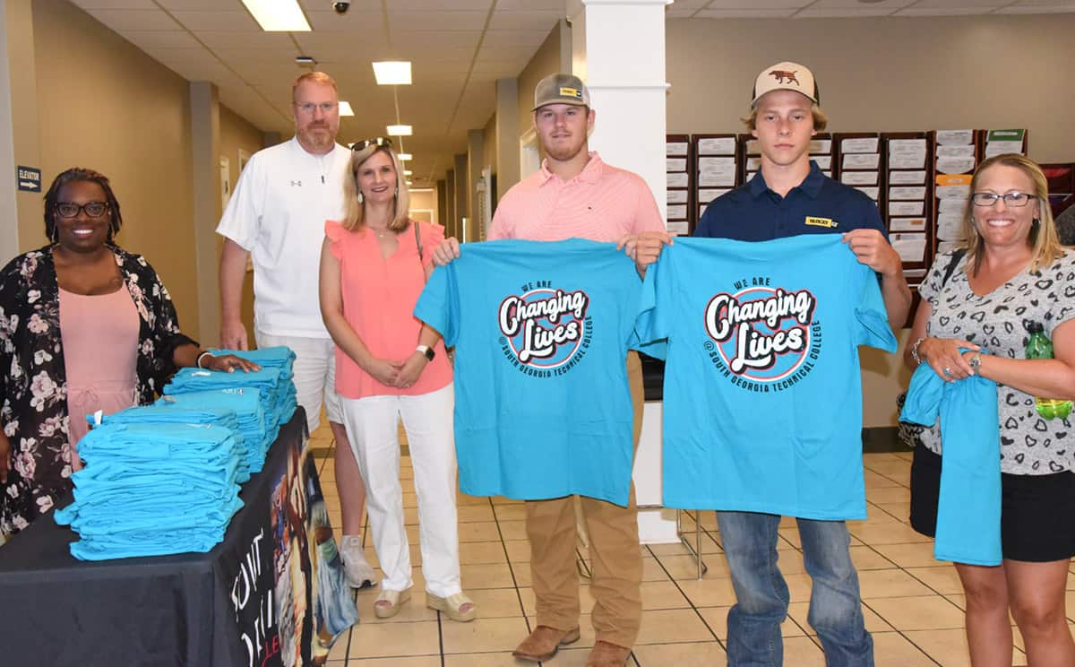 Shown above are some of the Caterpillar students and families displaying the free Changing Lives t-shirts that they received at the orientation/registration day at SGTC.
