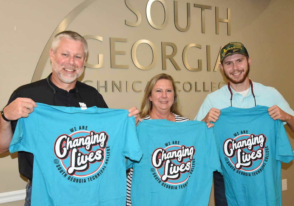 Shown above are some of the John Deere students and families displaying the free Changing Lives t-shirts that they received at the orientation/registration day at SGTC.