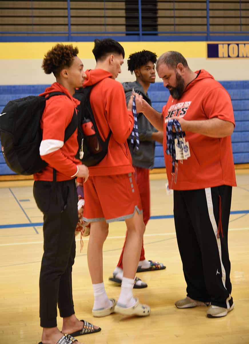 South Georgia Technical College head basketball coach Chris Ballauer is shown above handing out team pass credentials to the Jets following a practice at Hutchinson High School on Monday.