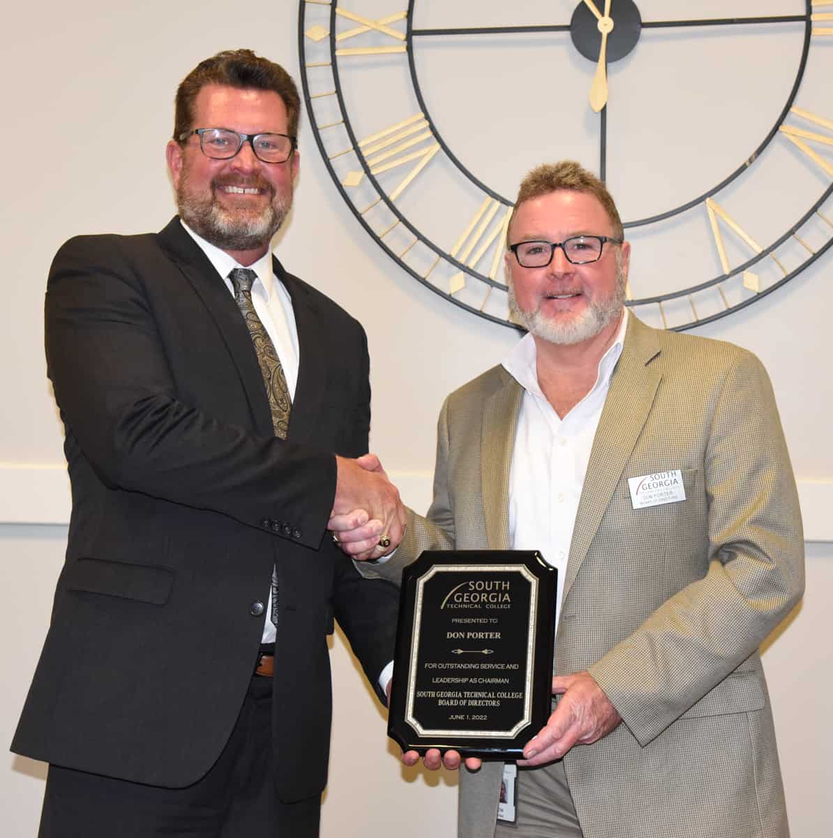 : SGTC President Dr. John Watford (left) is shown above presenting outgoing SGTC Board of Directors Chair Don Porter of Georgia Power (right) with a token of appreciation for his service as Chair of the Board for the 2021 – 2022 years.