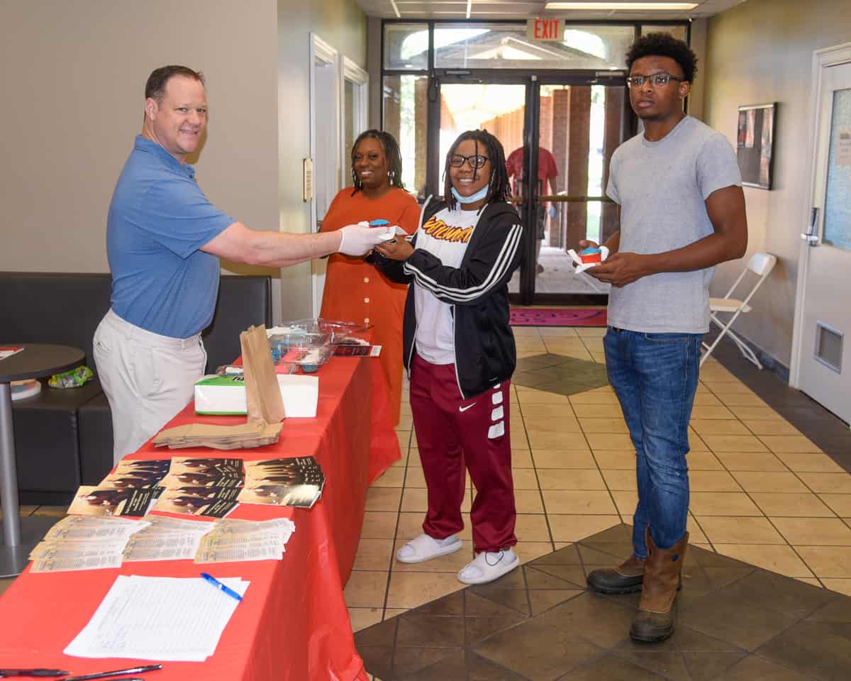 SGTC Assistant Vice President of Student Affairs Josh Curtin (left) hands Marketing Management student Jychera Fluellen of Sparta a cupcake during the recent Constitution Day commemoration while Air Conditioning Technology student Keith Bell of Americus (right) and SGTC Special Services Coordinator Jennifer Robinson look on.
