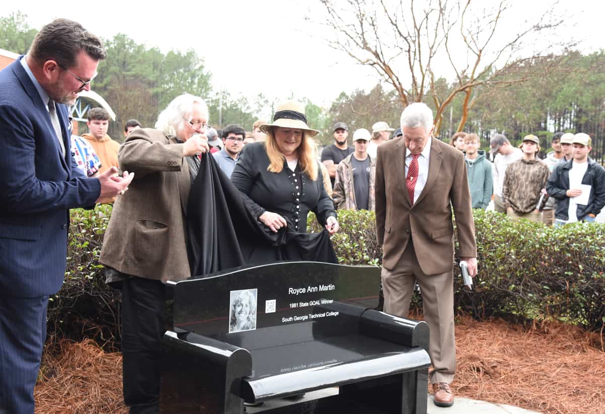 South Georgia Technical College President Dr. John Watford is shown above with Phil Martin, Royce Ann Martin and retired Aviation Maintenance Instructor Frank Gassett as they uncover the black marble bench placed in her honor outside of the Griffin Bell Aerospace Center on the SGTC campus.