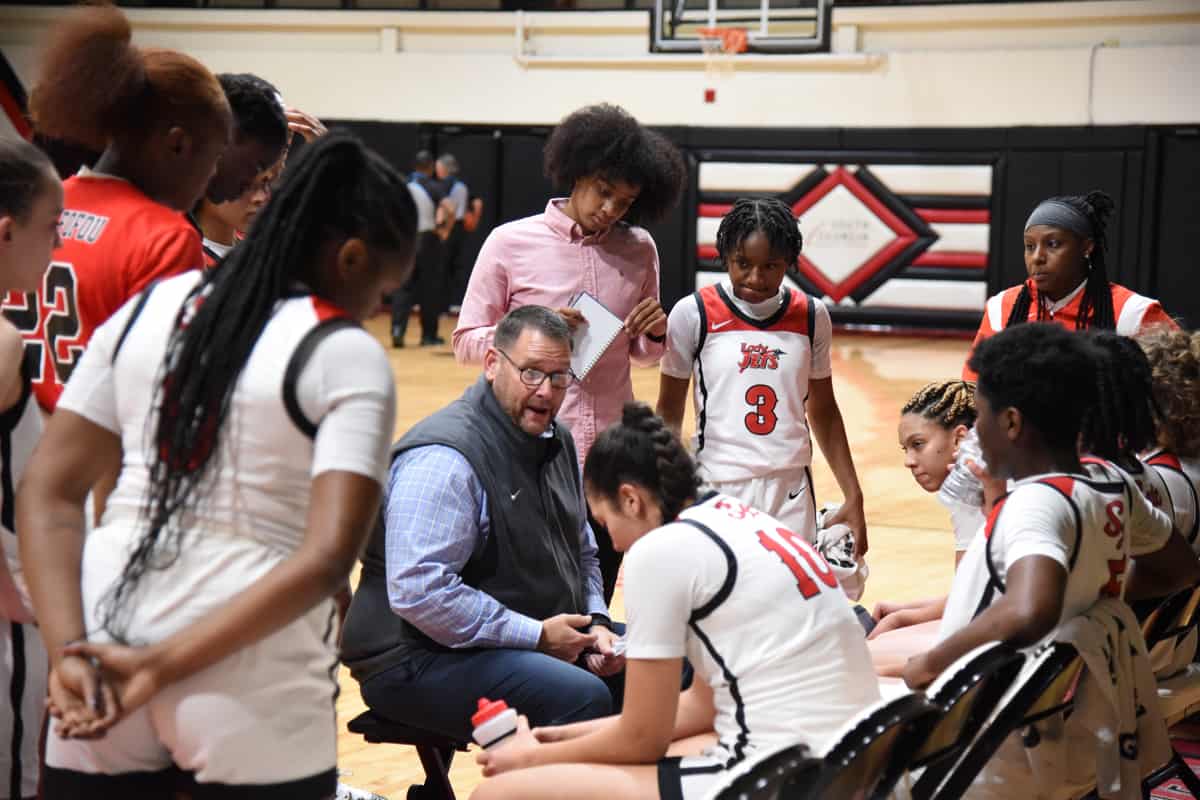 SGTC head coach is talking with his team during a fourth quarter time-out.