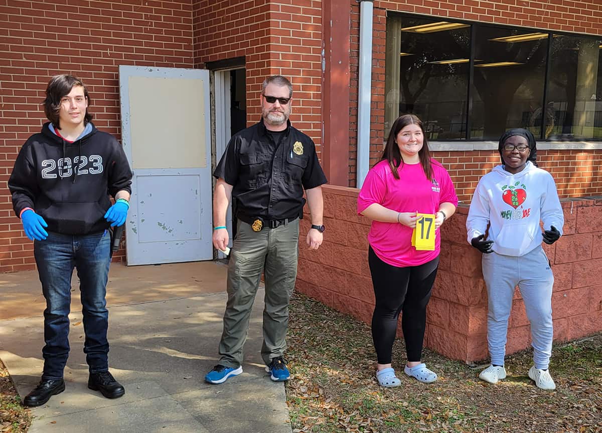 John Welch is shown above Brantley Vansickle, Ashlyn Childs, and Traneisha Burns helping prepare them for their SkillsUSA competitions.