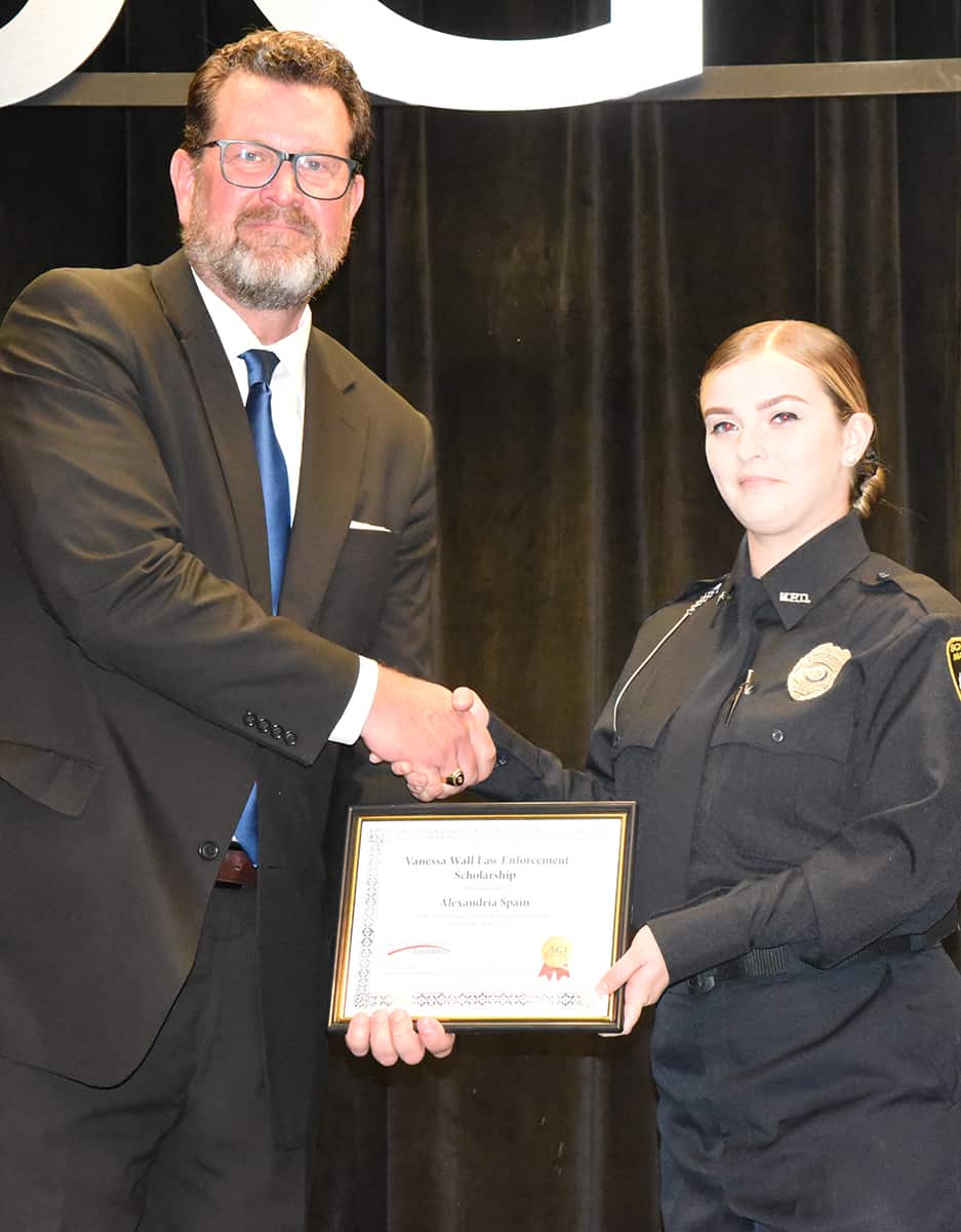 South Georgia Technical College President Dr. John Watford is shown above presenting Alexandria Spain with the Chief Vanessa Wall Criminal Justice/Law Enforcement Academy scholarship at the graduation ceremony for Class 23-01.