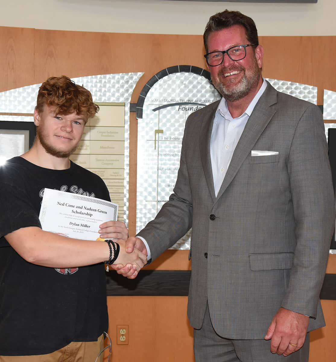 South Georgia Technical College President Dr. John Watford is shown presenting Dylan Miller, an Aviation Maintenance Technology student, with a certificate for receiving the Nadeen Green – Ned Cone Scholarship.