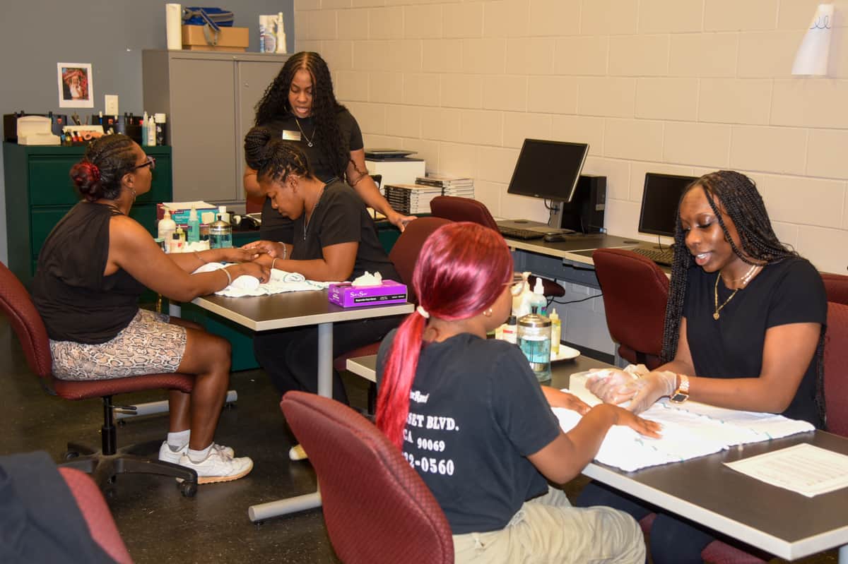 SGTC Nail Tech instructor Jessakeetha Maddox (standing) supervises her students Chamia Thomas of Ellaville and Briyanna Phelps of Andersonville (right) as they work with volunteers Kimberly Stackhouse and Kadija Usry, respectively.