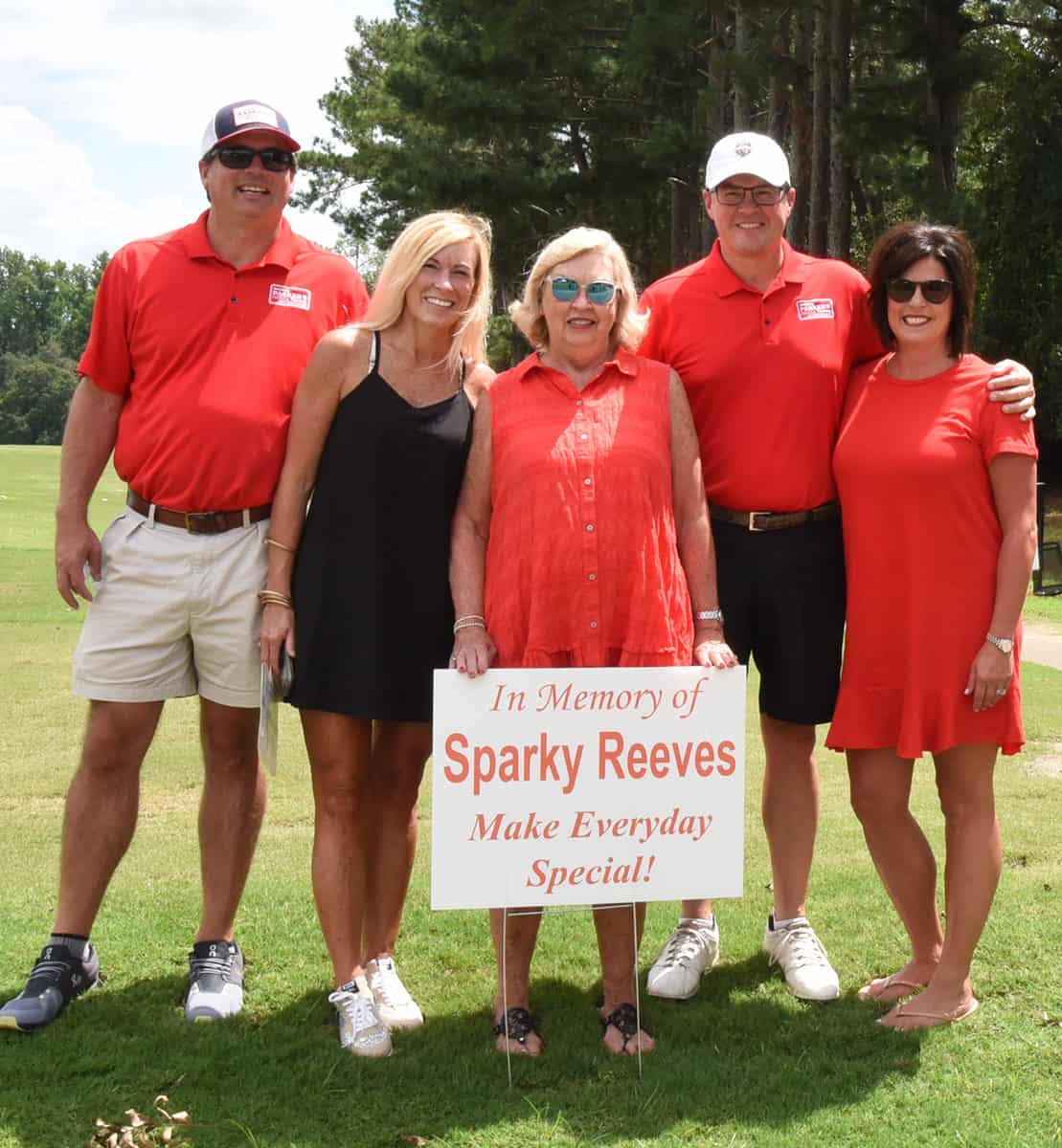 Sparky Strong – Shown above are members of the Reeves family showing their support of the SGTC Sparky Reeves Golf Tournament Classic. Shown (l to r) are: Ryan and Mandy Reeves Young, Allene Reeves, and Kevin and Jenny Reeves with the In Memory of Sparky Reeves hole sponsor sign placed on the first tee.