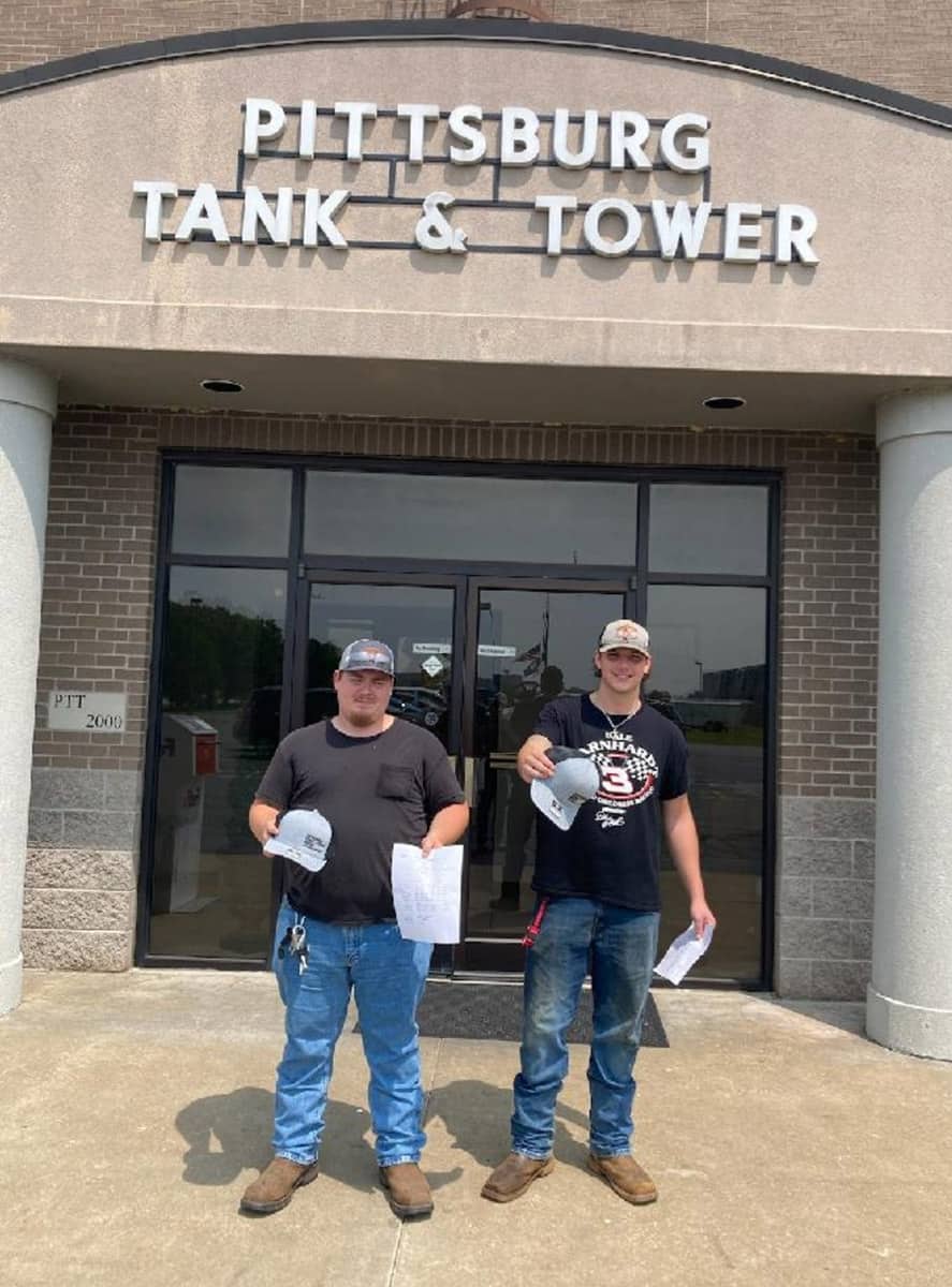 Joel Trevor Ferguson and Clarence Saint, SGTC Welding graduates, are shown in front of the entrance to Pittsburg Tank and Tower in Henderson, KY, where they were both hired after graduation.