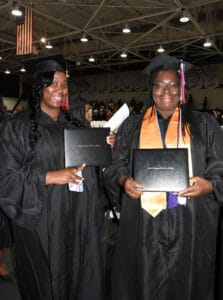 These two individuals proudly display their diplomas at the Fall graduation.