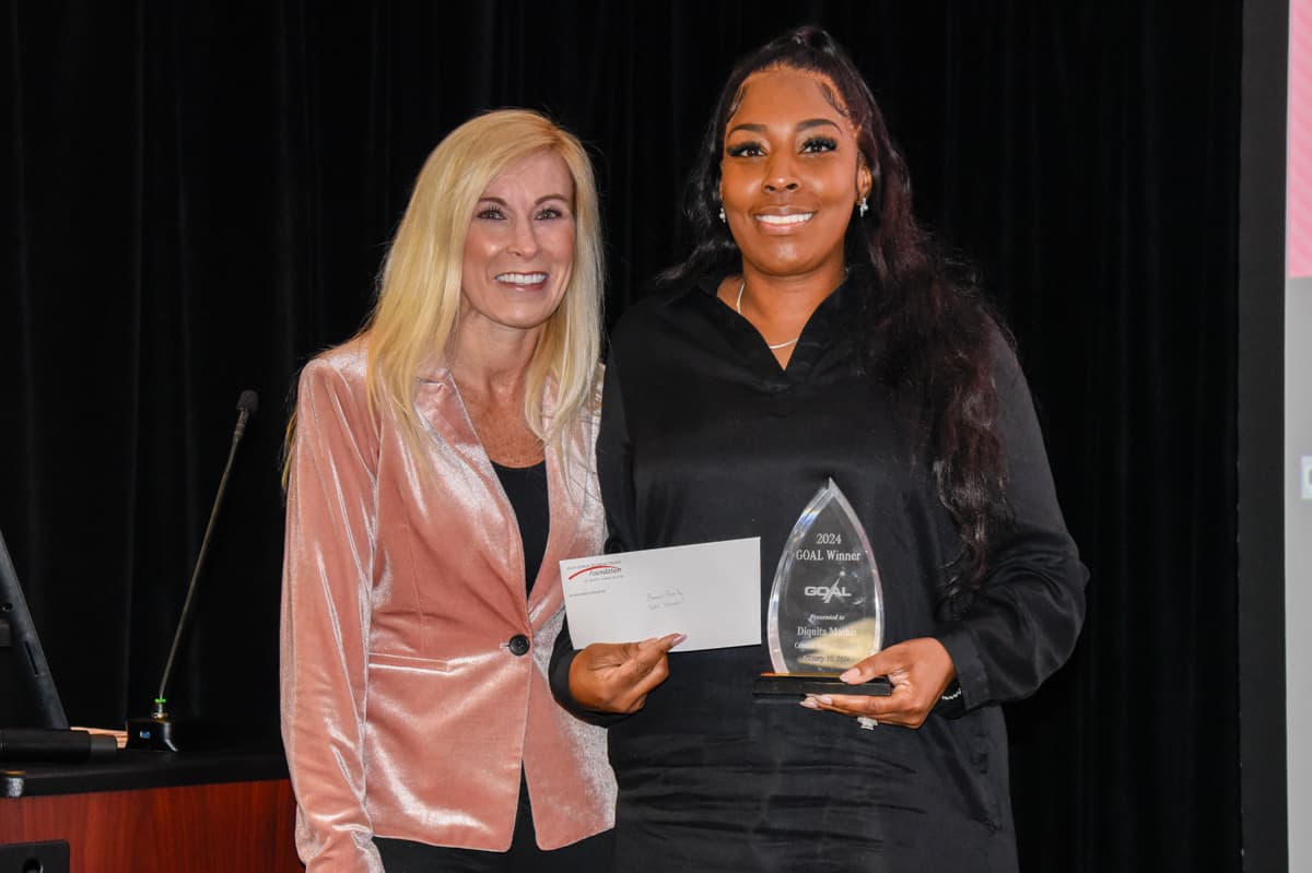 Mandy Reeves Young (l), is shown above presenting a scholarship check to 2024 GOAL winner Diquita Mathis (r).